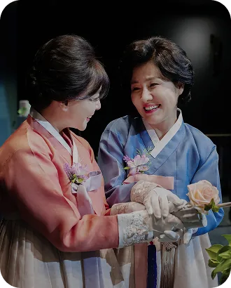 한복을 입고 마주 보며 웃는 양가 어머님