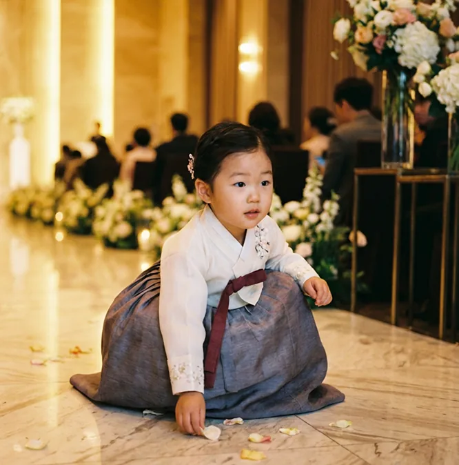 식장 바닥의 꽃잎을 줍는 아이